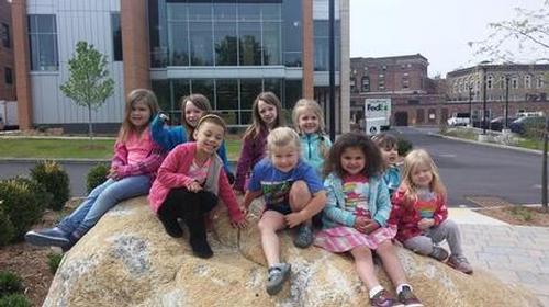 Children enjoying the big rocks in the park by the library.